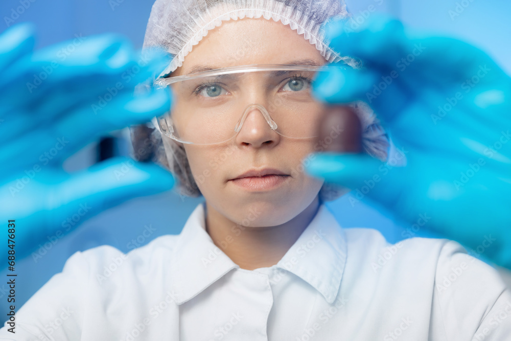 Food industry, candy factory, worker chemist tests chocolate products