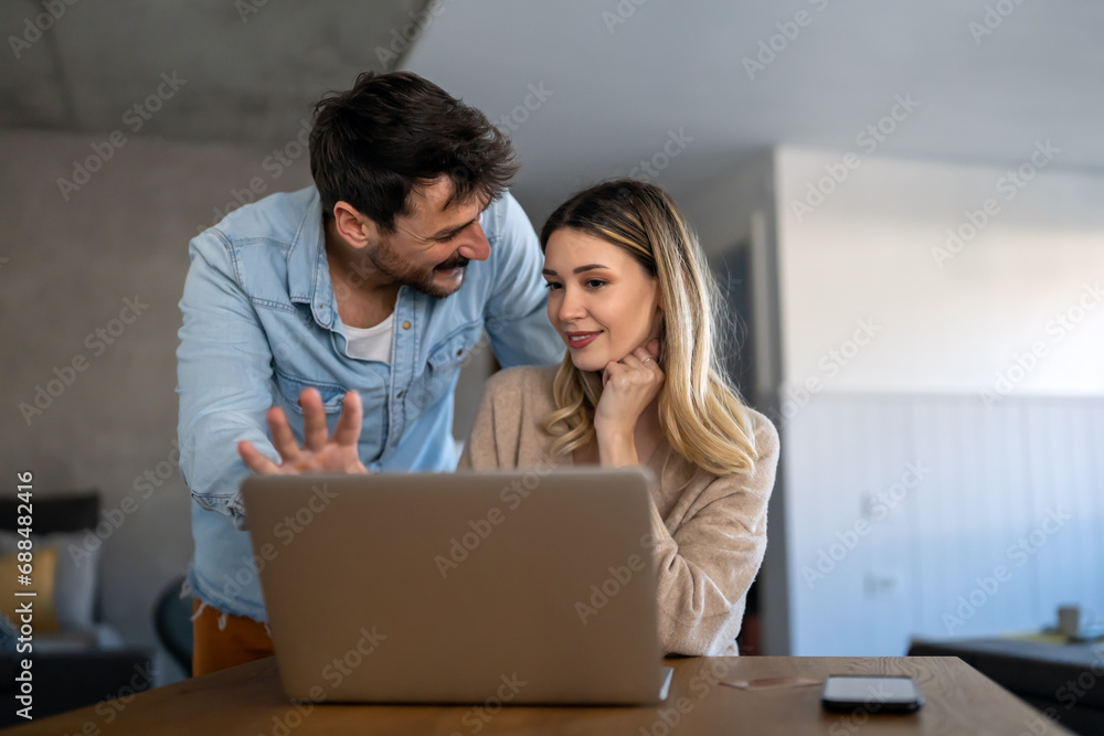 Multiethnic colleagues discussing project while working with laptop in office indoors Multiethnic colleagues discussing project while working with laptop in office indoors