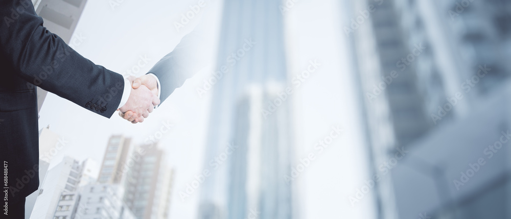 Close up of handshake on wide city background with mock up place. Teamwork and success concept. Double exposure. Close up of handshake on wide city background with mock up place. Teamwork and success concept. Double exposure.