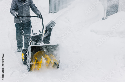 Snowplow. Man removes snow with a snowblower in winter day