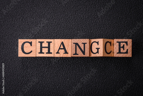 The inscription chance or change with wooden cubes on a dark concrete background