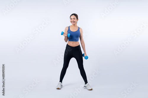 Vigorous energetic woman doing dumbbell weight lifting exercise on isolated background. Young athletic asian woman strength and endurance training session as body workout routine.