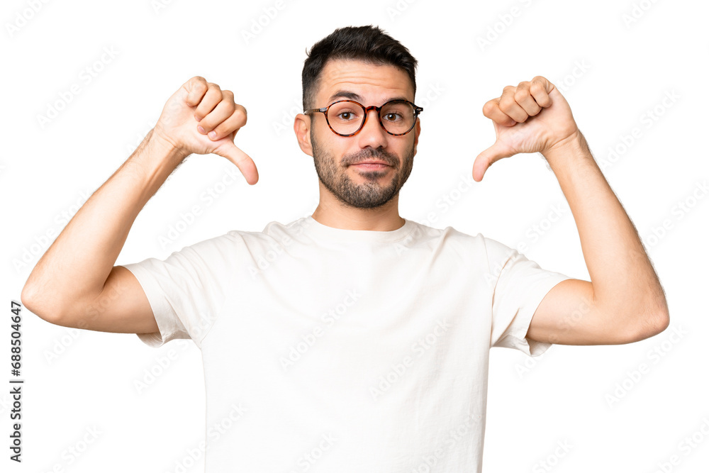 Fototapeta premium Young handsome caucasian man over isolated chroma key background showing thumb down with two hands