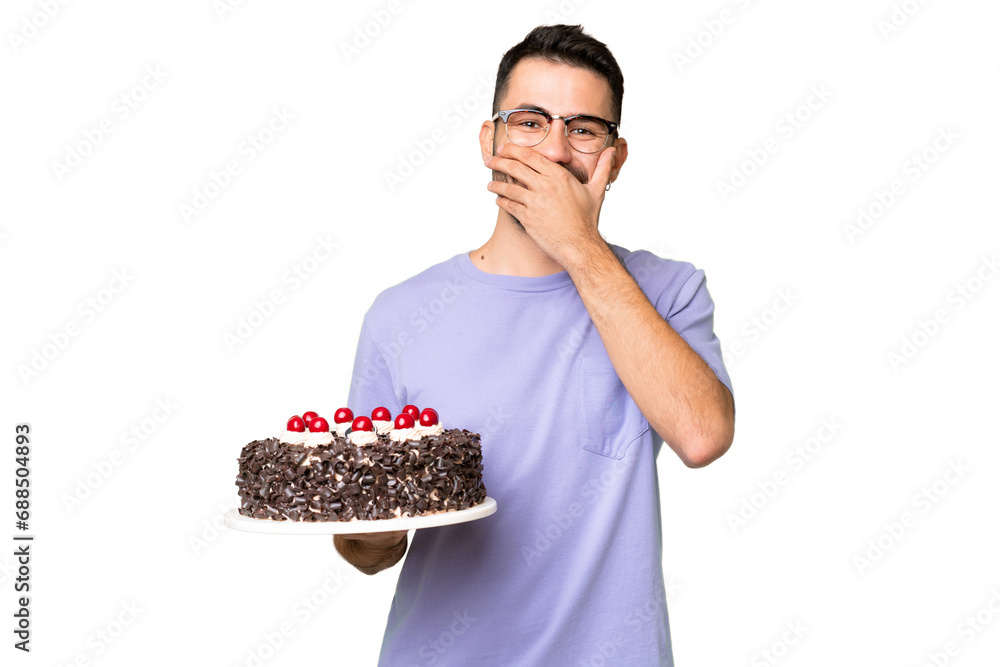 Young caucasian man holding birthday cake isolated on green chrome background happy and smiling covering mouth with hand Young caucasian man holding birthday cake isolated on green chrome background happy and smiling covering mouth with hand