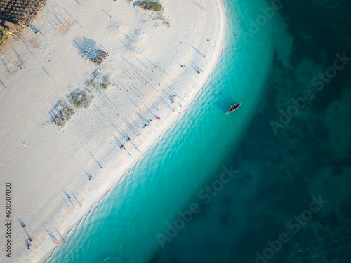 Birds view of dhow boat in the green ocean and wonderful white sandy beach, copy space, Zanzibar in Tanzania.