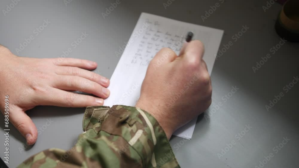 An unrecognizable army soldier marine writing a letter home on a table ...