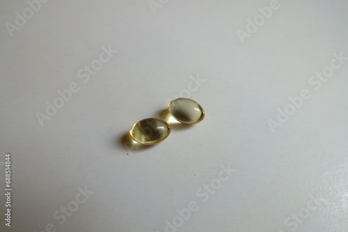 Yellow transparent softgel capsules of vitamin D (two items)
