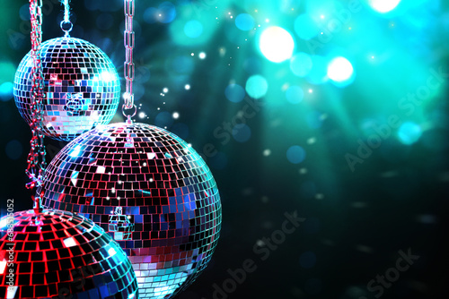 Shiny disco balls on dark cyan background with blurred lights  space for text. Bokeh effect