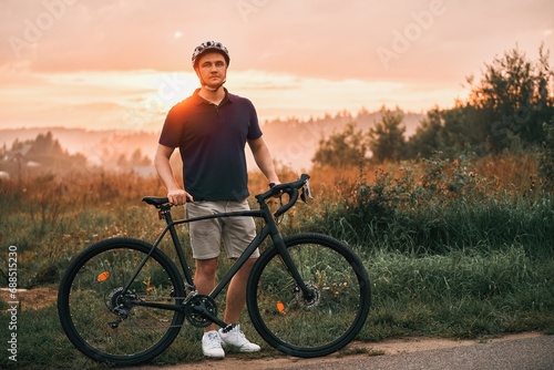 A silhouette of a cyclist training on a trail with a gravel bike, enjoying the adventure and the sport concept in the sunset. photo