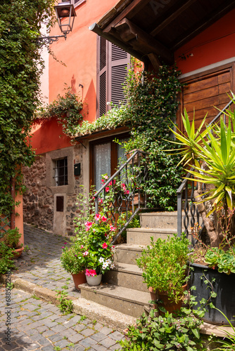 Narrow street of small town with many flowers in Italy