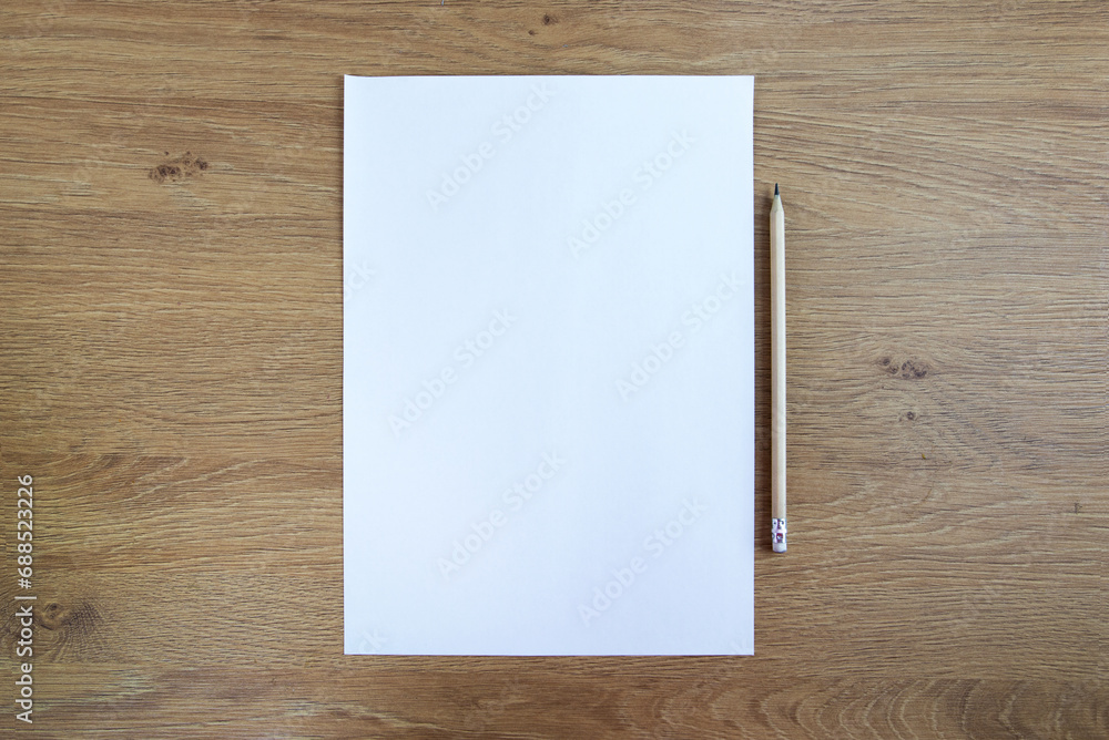 blank sheet of paper and pencil on a wooden table.Space for your text. blank sheet of paper and pencil on a wooden table.Space for your text.