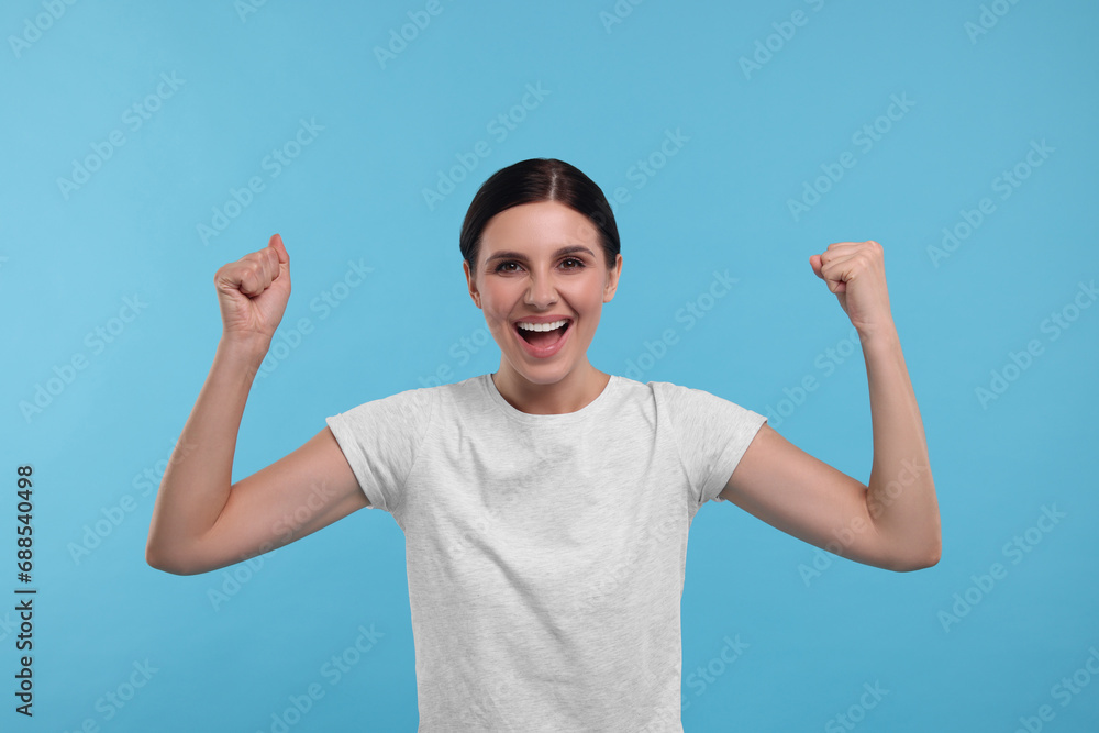 Naklejka premium Emotional sports fan celebrating on light blue background