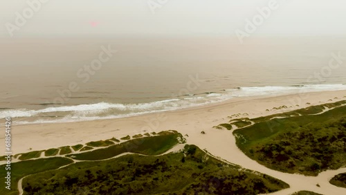 Drone shot of the ocean's coastline in Florence, Oregon near Jessie M. Honeyman Memorial State Park. photo