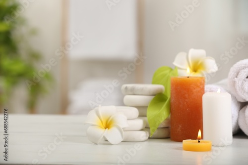 Composition with different spa products and plumeria flowers on white table indoors, space for text
