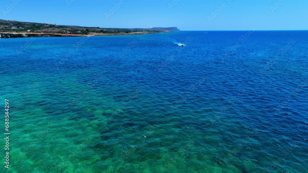Aerial Forward Shot Of Motorboats Moving On Waves In Sea By Cliff Against Blue Clear Sky - Famagusta, Cyprus Aerial Forward Shot Of Motorboats Moving On Waves In Sea By Cliff Against Blue Clear Sky - Famagusta, Cyprus