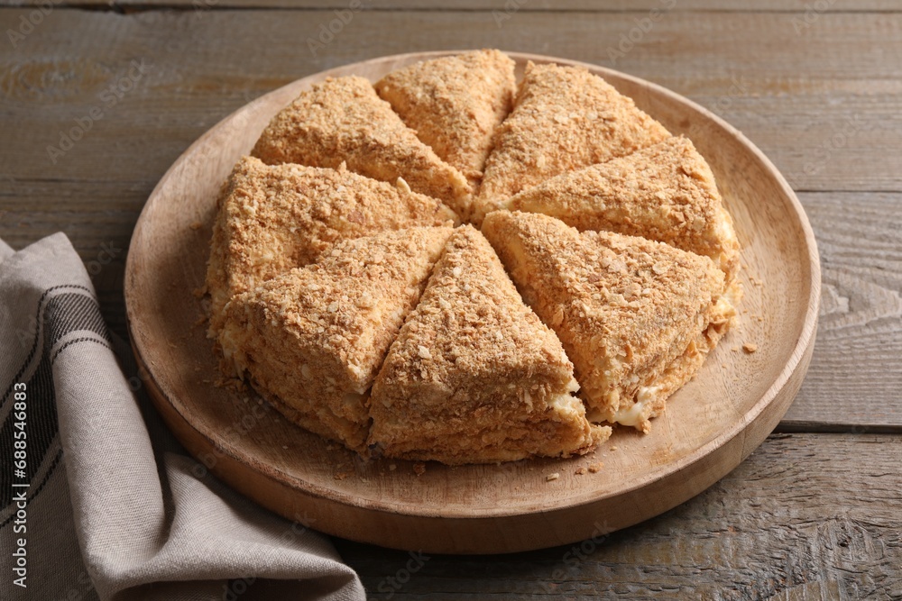 Delicious cut Napoleon cake on wooden table, closeup Delicious cut Napoleon cake on wooden table, closeup