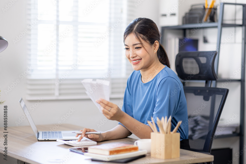 asian woman using calculator and calculate bills in home office. tax form us business income office Financial document. Tax time.Tax concept. asian woman using calculator and calculate bills in home office. tax form us business income office Financial document. Tax time.Tax concept.