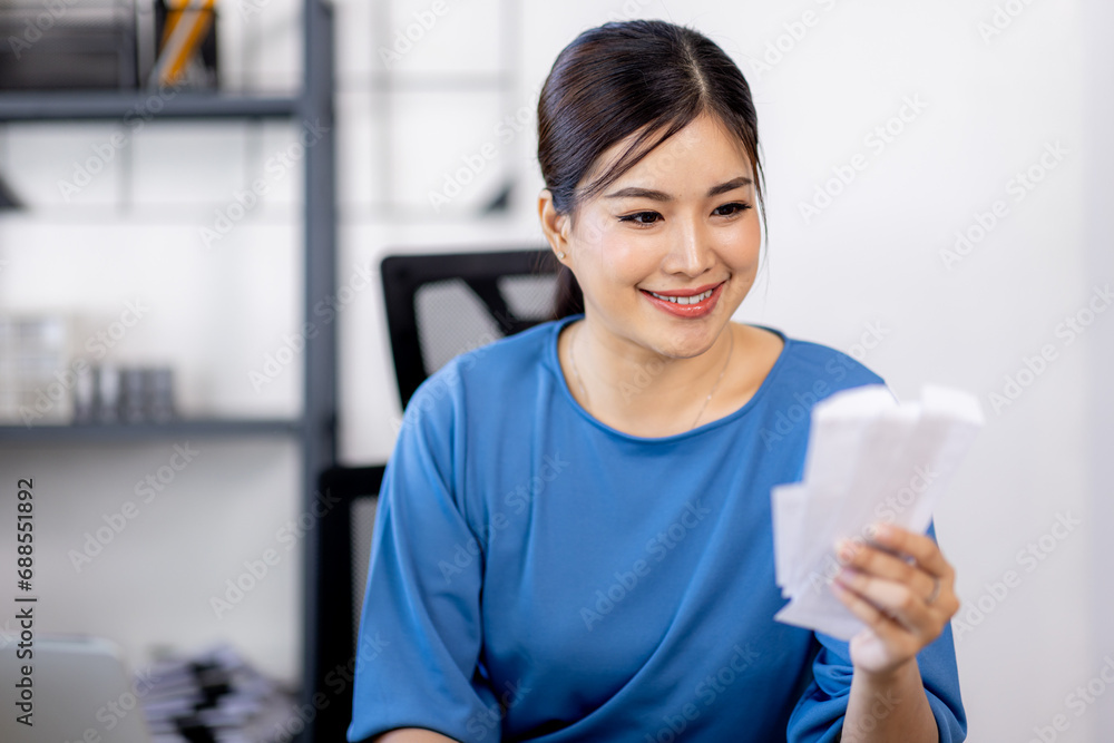 asian woman using calculator and calculate bills in home office. tax form us business income office Financial document. Tax time.Tax concept. asian woman using calculator and calculate bills in home office. tax form us business income office Financial document. Tax time.Tax concept.