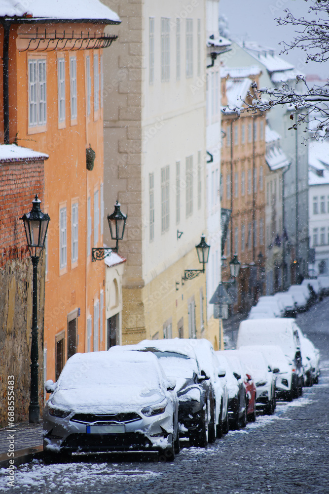 Prague city street under the snow. Cars driving on a blizzard road. Snow calamity in the city. Snow covered cars. Winter
