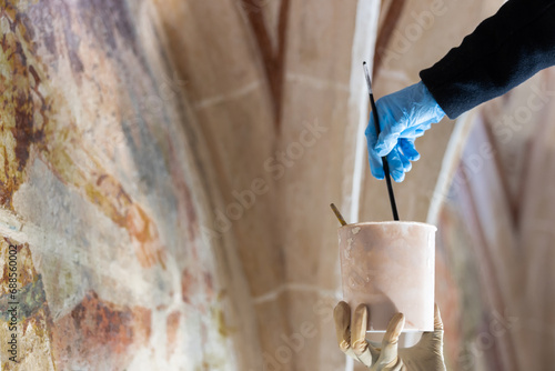 Painter Hands Restoration Work On Gothic Fresco in Historic Church. Skilled and Confident Artisan at Work photo