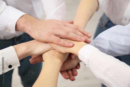 People holding hands together in office, closeup