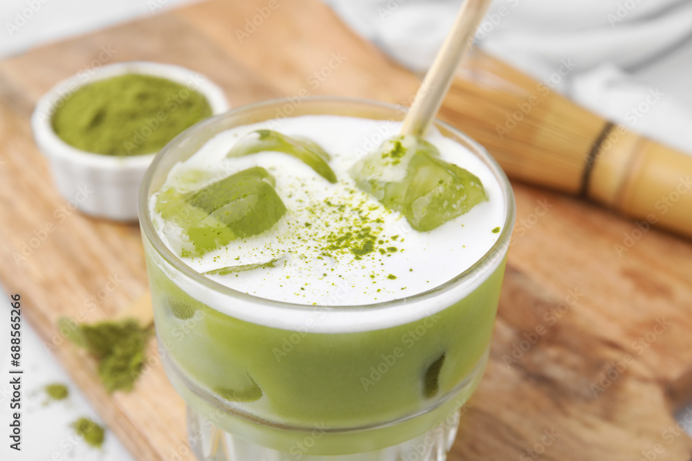 Glass of tasty iced matcha latte on wooden board, closeup Glass of tasty iced matcha latte on wooden board, closeup