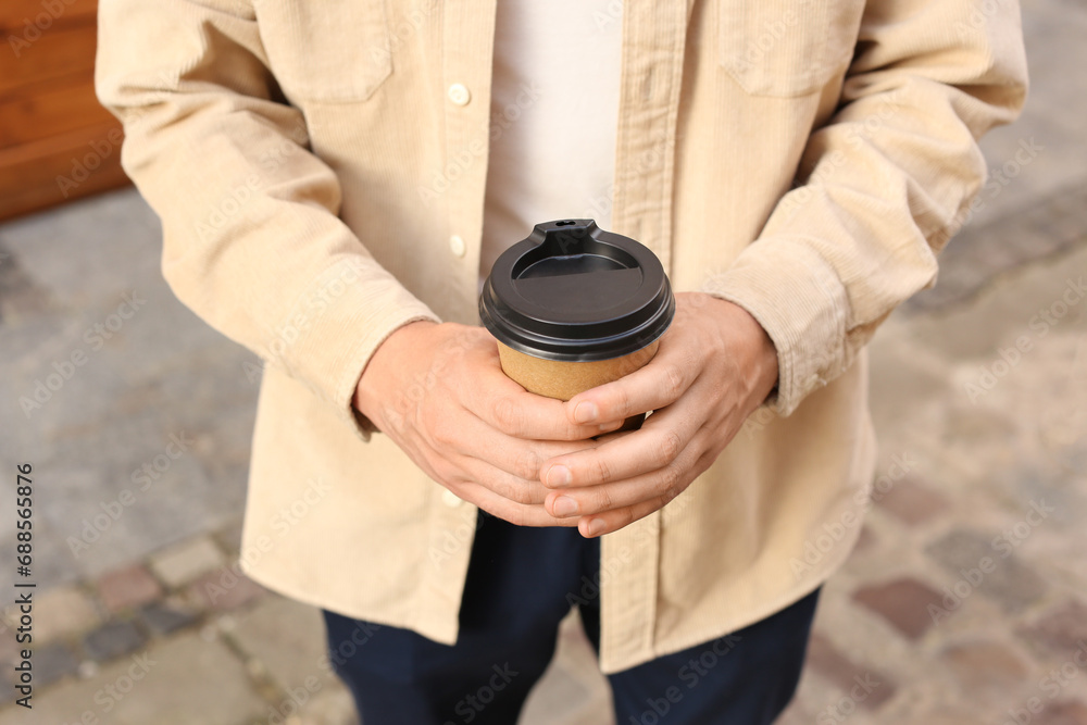 Coffee to go. Man with paper cup of drink outdoors, closeup Coffee to go. Man with paper cup of drink outdoors, closeup