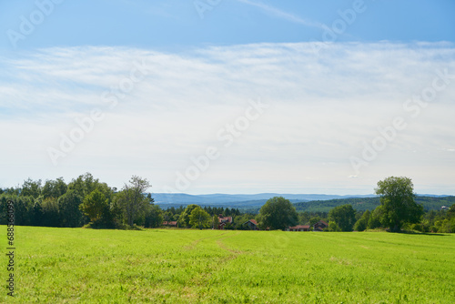 Green field on farmland with cloudy sky in Sweden in summer