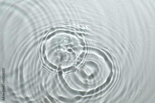 Rippled surface of clear water on light grey background, top view