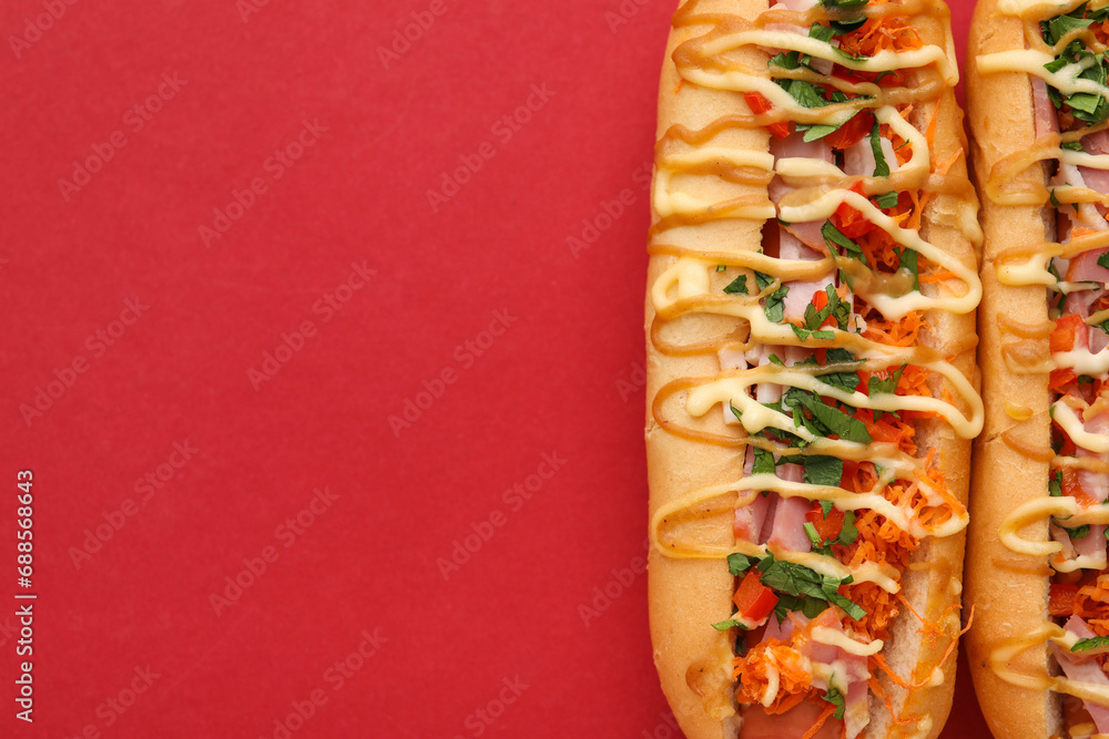 Delicious hot dogs with bacon, carrot and parsley on red background, top view. Space for text - obrazy, fototapety, plakaty 
