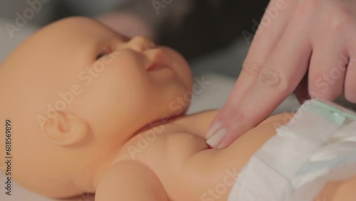 Woman performing CPR on baby training doll  photo