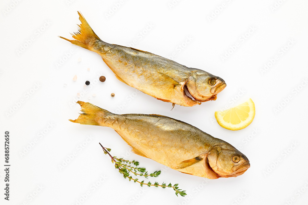 Cold smoked sea fish carcass close up isolated on white background decorated with fresh sprig of thyme, lemon, crystals of coarse pink salt, black peppercorns. Salty snacks. Omega3 Cold smoked sea fish carcass close up isolated on white background decorated with fresh sprig of thyme, lemon, crystals of coarse pink salt, black peppercorns. Salty snacks. Omega3