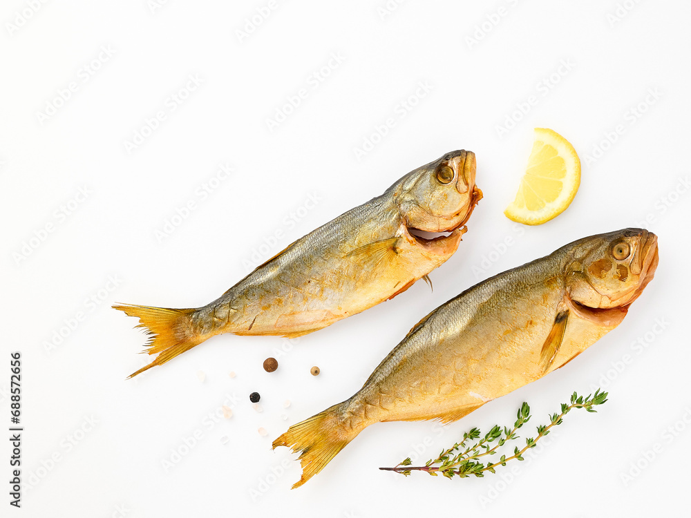 Cold smoked sea fish carcass close up isolated on white background decorated with fresh sprig of thyme, lemon, crystals of coarse pink salt, black peppercorns. Salty snacks. Omega3 Cold smoked sea fish carcass close up isolated on white background decorated with fresh sprig of thyme, lemon, crystals of coarse pink salt, black peppercorns. Salty snacks. Omega3