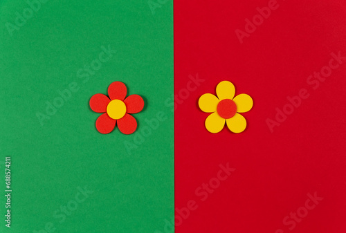 Colorful red and green paper background with two flowers in the middle.
