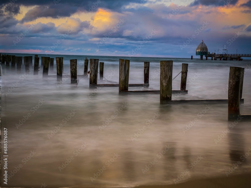 Wooden posts emerge from the misty waters of the Baltic Sea at Zingst, Germany