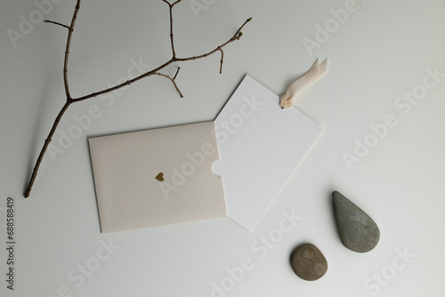 Composition with a dry branch with stones and a gift envelope