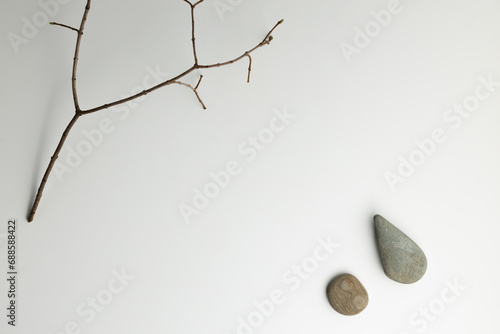 The composition of a dry branch with stones is photographed from above, there is a place for an inscription