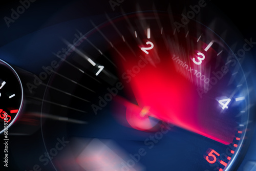 Motion blur of a car instrument panel dashboard odometer with red illuminated display.Car speedometer. High speed car speedometer and motion blur at night. photo