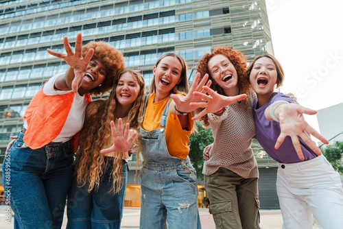 Schilderij op canvas Group of young adult women smiling and gesturing at camera together