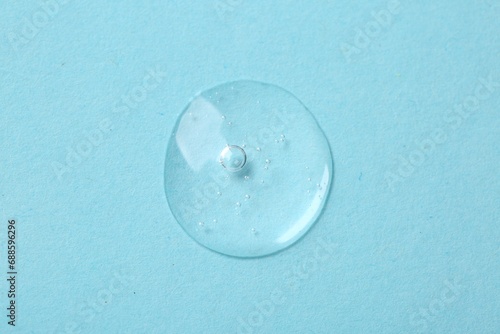 Sample of cosmetic serum on light blue background  top view