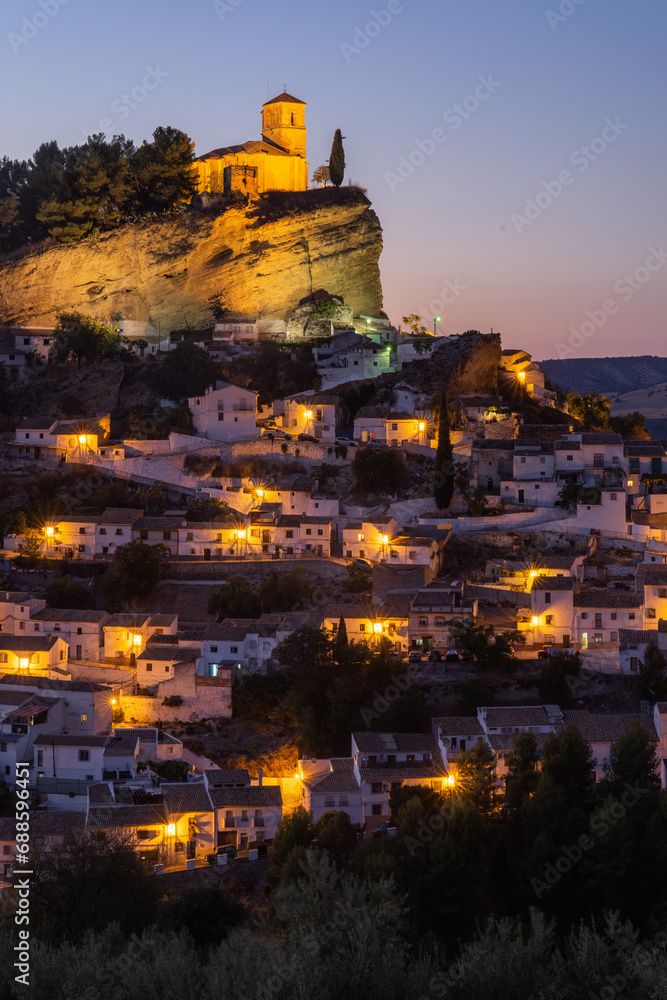 Panoramic view of Montefrio since National Geographic lookout with olive trees in the foreground illuminated at night. Granada, Andalucia, Spain.