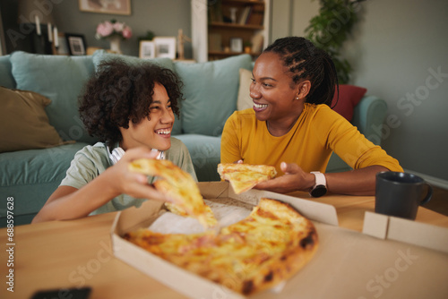 Mother and teenage son having pizza at home photo