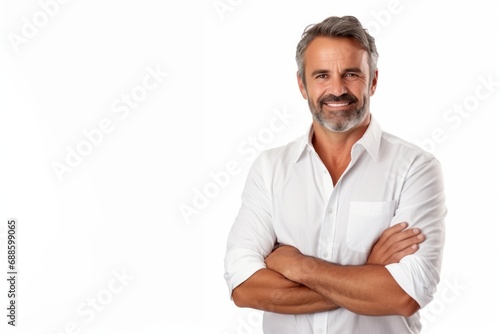 Smiling middle-aged man with folded arms and a deadpan expression posing in front of a white background with copy space photo