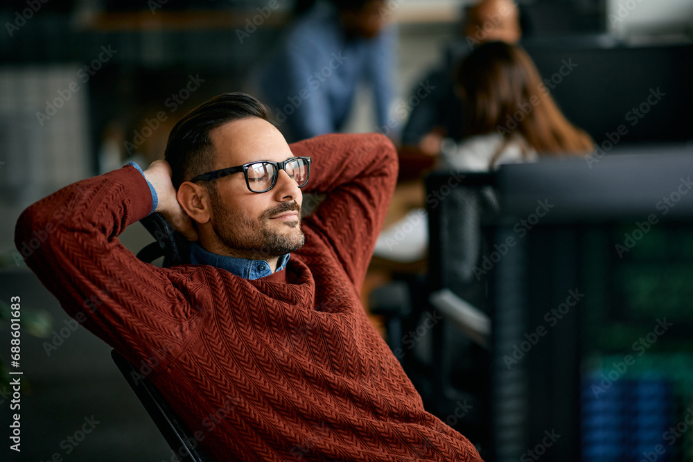 Smiling IT engineer taking break from working on computer in office. Smiling IT engineer taking break from working on computer in office.
