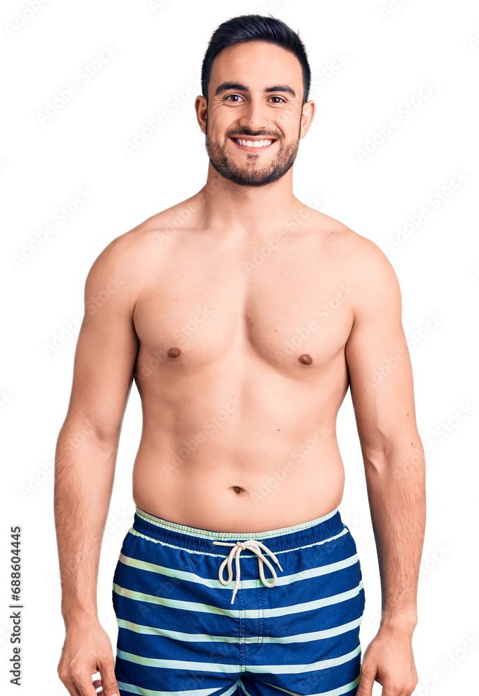 Fototapeta premium Young handsome man wearing swimwear with a happy and cool smile on face. lucky person.