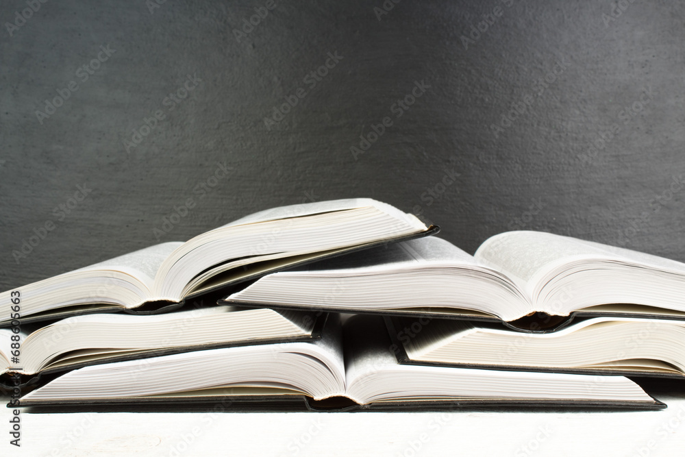 Obraz premium Open book on wooden deck table and black board background. Back to School. Education concept with copy space for your ad text.