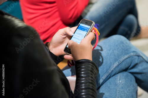 Digital Connection: Woman Engaged with Illuminated Mobile App, Back View