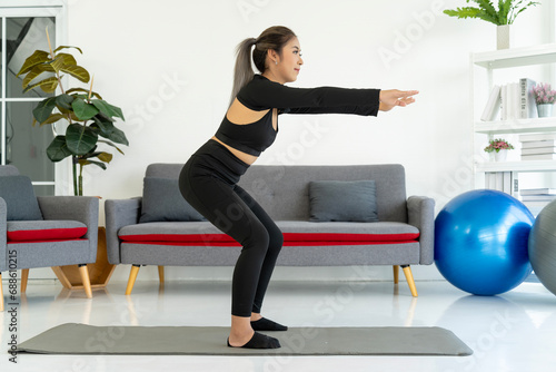 Fototapeta Naklejka Na Ścianę i Meble -  Squatting Exercise, Woman On Yoga Mat, Indoor Living Room Workout