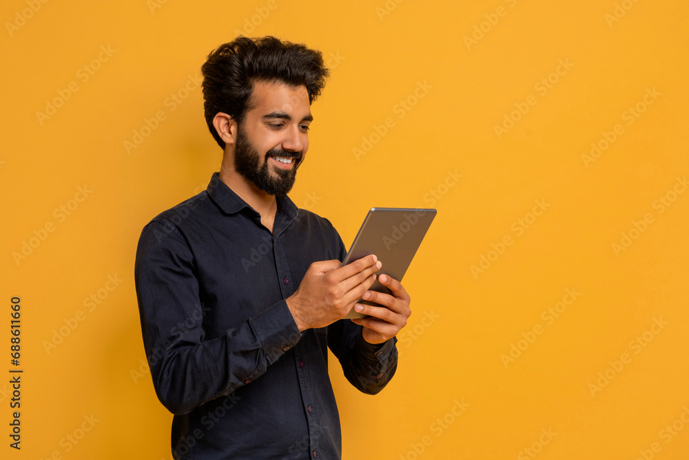 Great App. Smiling Young Indian Man Using Digital Tablet Great App. Smiling Young Indian Man Using Digital Tablet