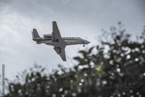 A small private passenger jet approaching land to land